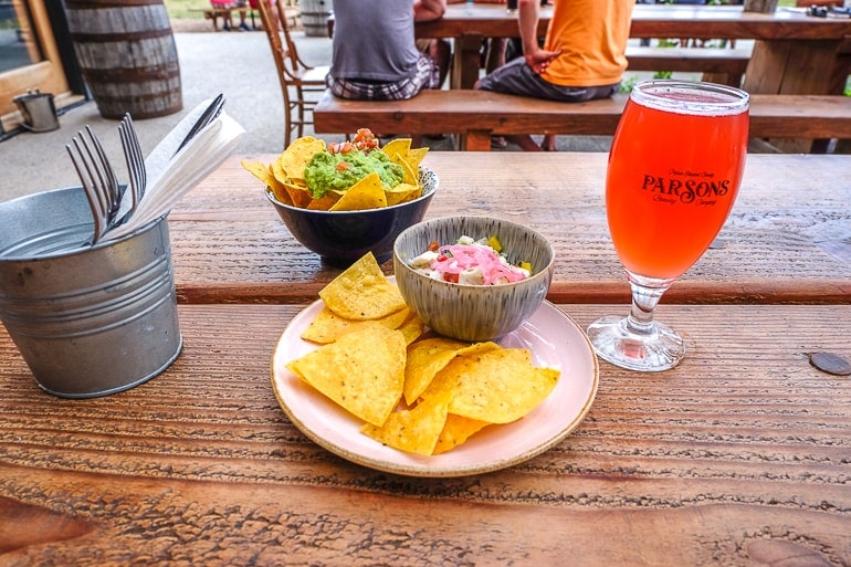 chips and salsa on plate with pint of beer on wooden table at parsons brewery prince edward county toronto day trip