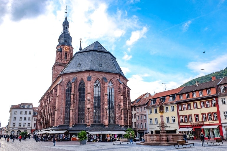 red church with tower in old market square in heidelberg germany things to do