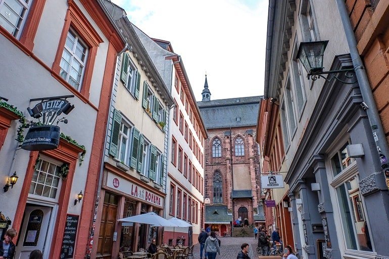 Bunte Gebäude entlang einer Gasse mit Läden in Heidelberg