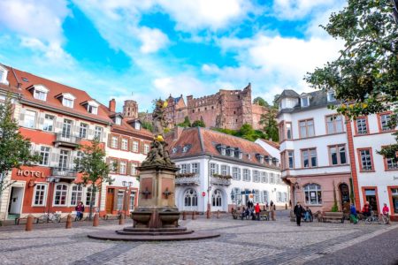 colourful old town square with fountain and castle behind things to do in heidelberg germany
