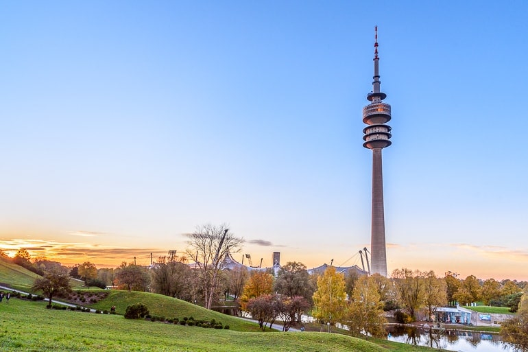 tv tower with blue sky and setting sun in behind in olympic park munich.