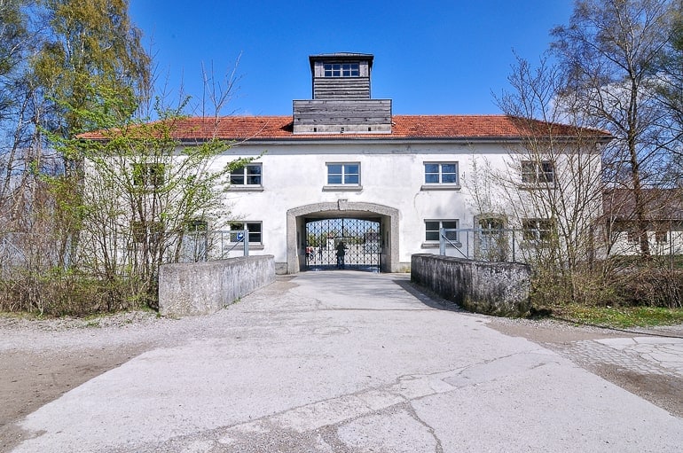 Weißes Gebäude mit Tor, Einfahrt und Straße KZ Gedenkstätte Dachau
