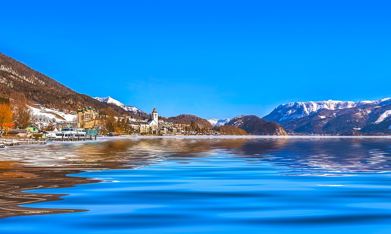 Blauer See mit schneebedecktem Seeufer und Seen im Hintergrund Wolfgangsee Ausflug