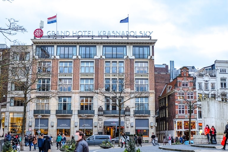 hotel with windows and flags overlooking city square amsterdam
