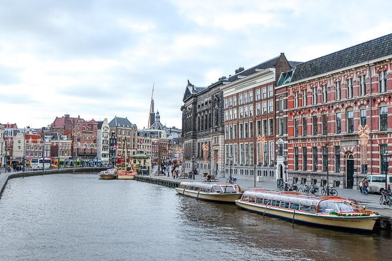 Bote in Kanal mit Gebäuden im Hintergrund Wo übernachten in Amsterdam
