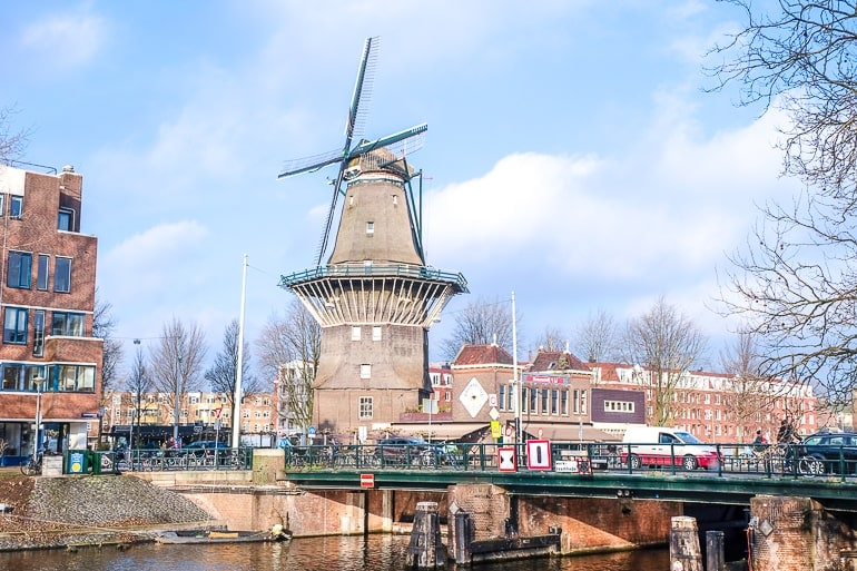 Große Windmühle mit blauem Himmel dahinter und Fluss davor in Zeeburg Amsterdam