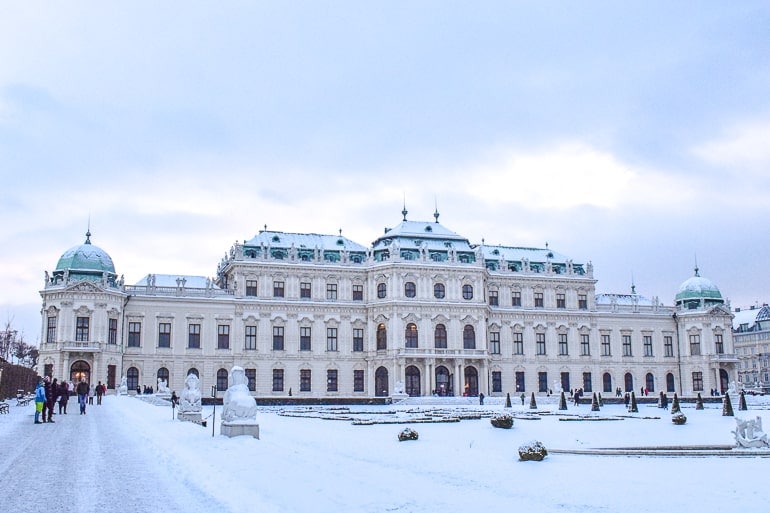 large palace building with snowy gardens in front in vienna