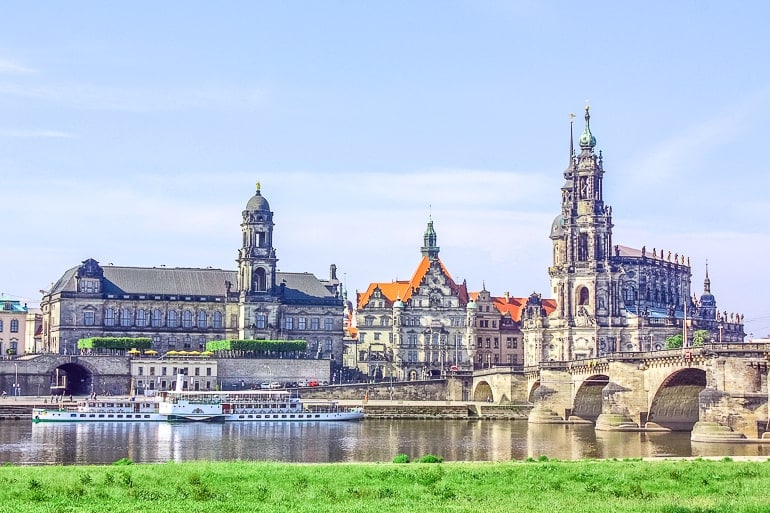tall church towers with old bridge crossing river in dresden germany itinerary