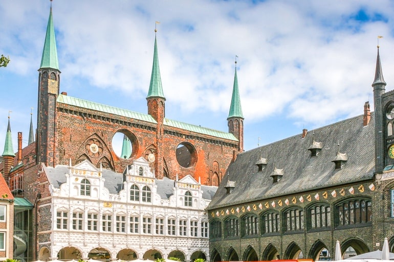Backsteinwand mit grünen Türmen und anderen alten Gebäuden in Lübeck Deutschland