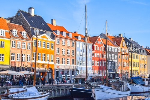 bunte Häuser am Hafen mit kleinen Bootem im Wasser davor in Kopenhagen Dänemark