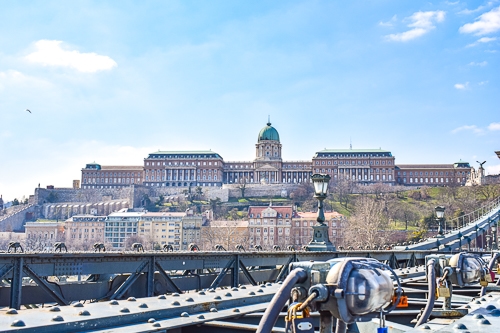large palace building with dome on hill in distance in budapest hungary