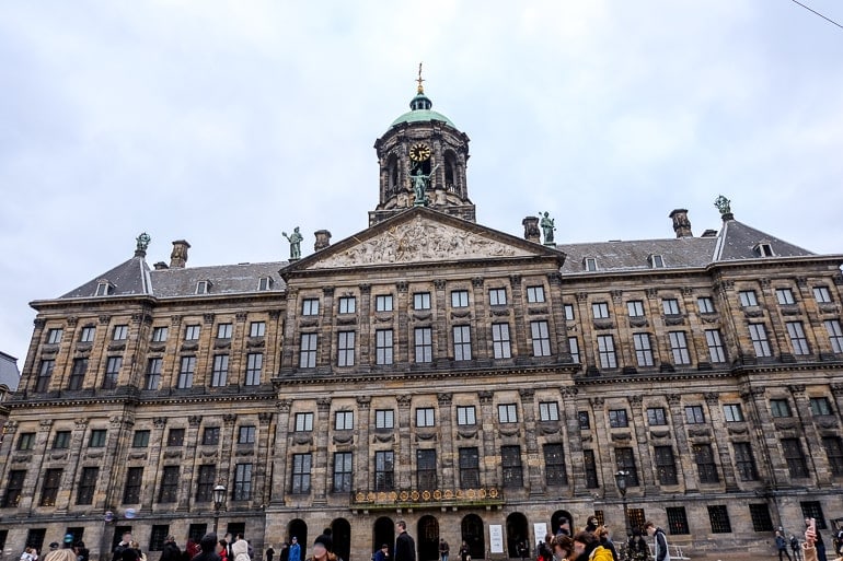 old palace building with clock tower in amsterdam city centre.