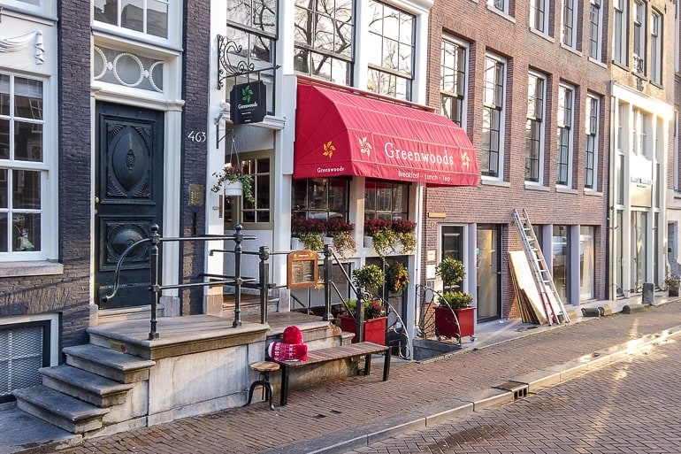 Rote Markise über Engang von Cafe an Grachten in Amsterdam.