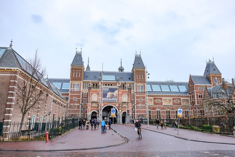 large red brick museum with wide lane in front in amsterdam.