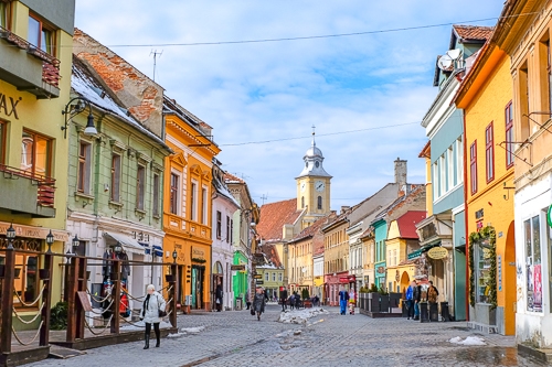 colourful street with shops and people in old town romania