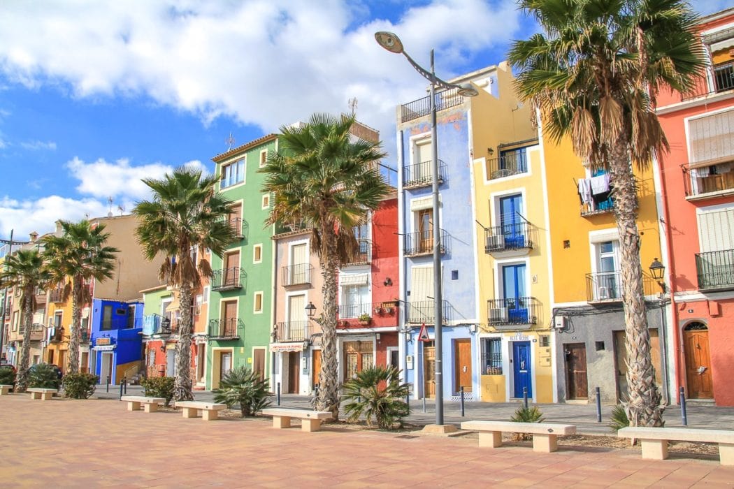 Bunte Häuser mit Palmen entlang des Gehwegs in Alicante