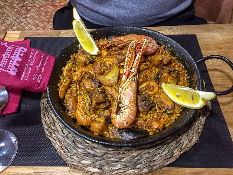 dish of paella on table with prawn and lemons alicante spain