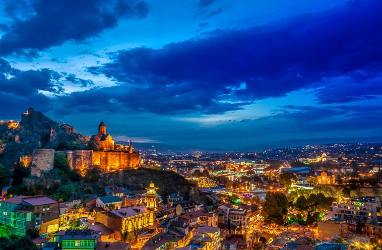 city lit up at night with church on hill in tbilisi