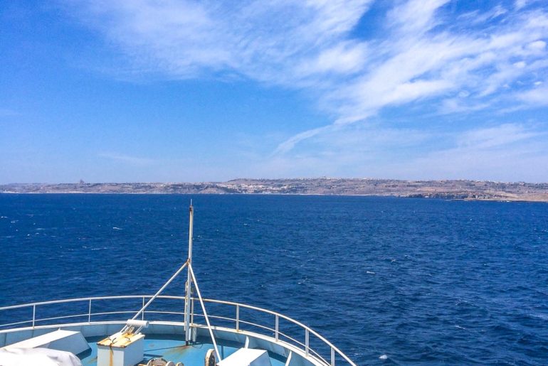 front of ferry boat with land and clouds ahead malta to gozo ferry