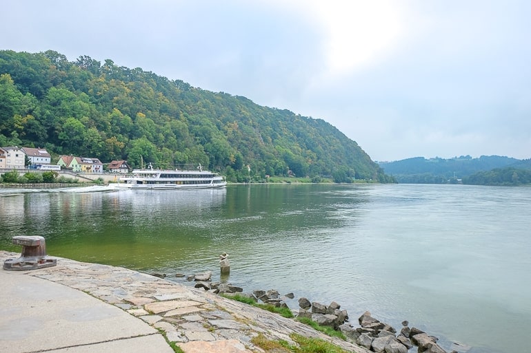 Weißes Boot auf der Donau mit grünem Gras an Ufer im Hintergrund