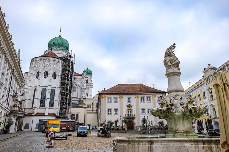 old town square with fountain and green dome in passau