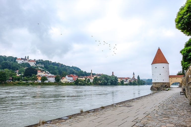 Weißer Turm mit rotem Dach neben dem Fluss in Passau