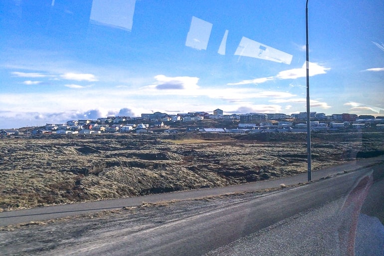 view from bus of small town on hillside in iceland