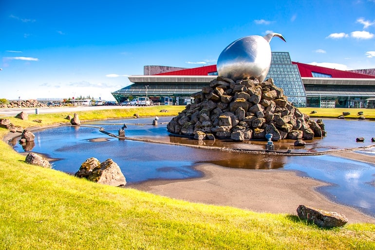Große Statue aus Metall auf Steinen in Teich außerhalb des Flughafengebäudes auf Island
