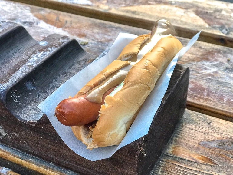 Isländischer Hotdog eingepackt in weißem Papier auf Holztisch