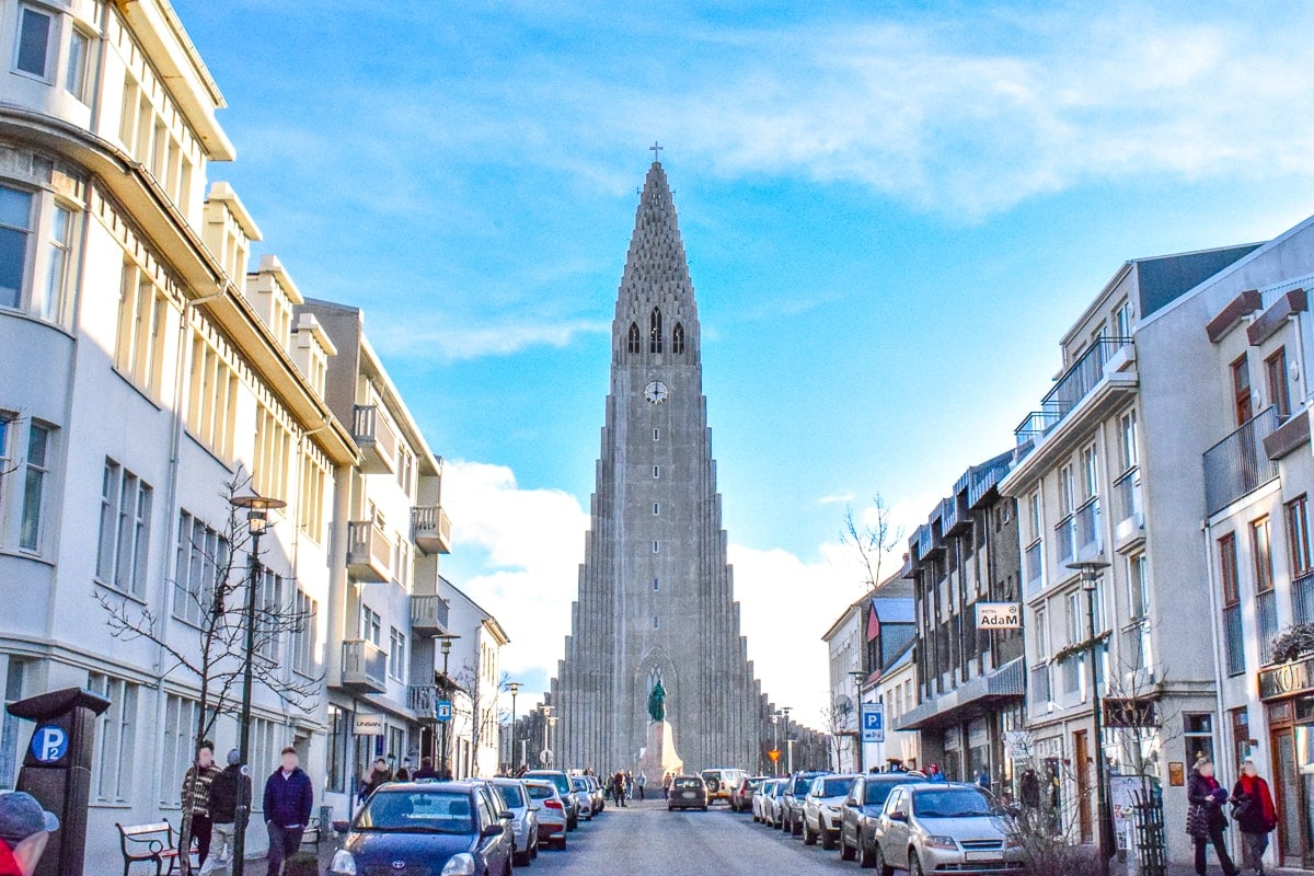 Große Betonkirche mit Blick auf eine belebte Straße mit parkenden Autos im Stadtzentrum von Reykjavik.