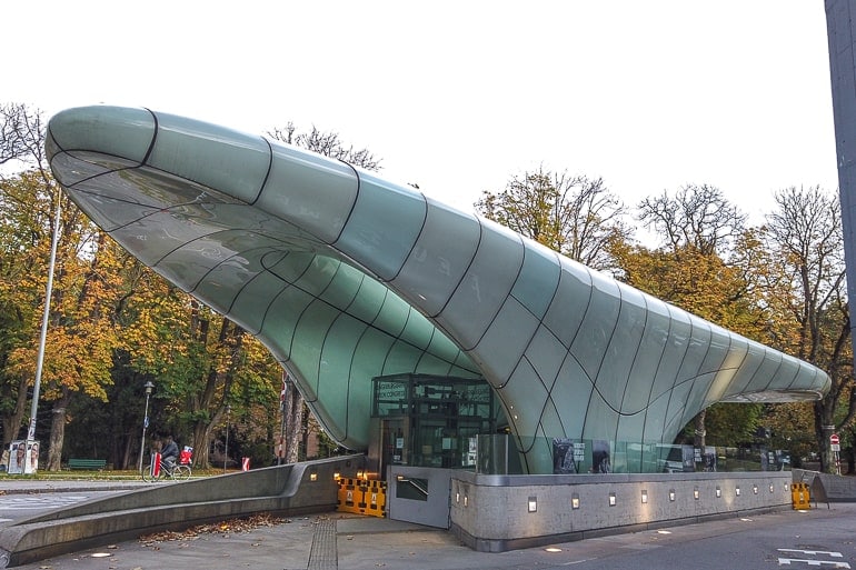futuristic entrance to cable car train in innsbruck in autumn trees behind.