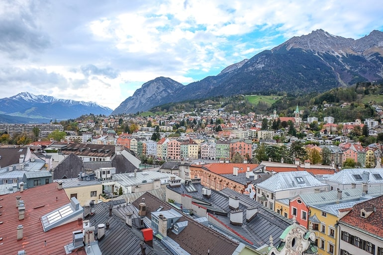 high view of colourful old town innsbruck with mountains behind.