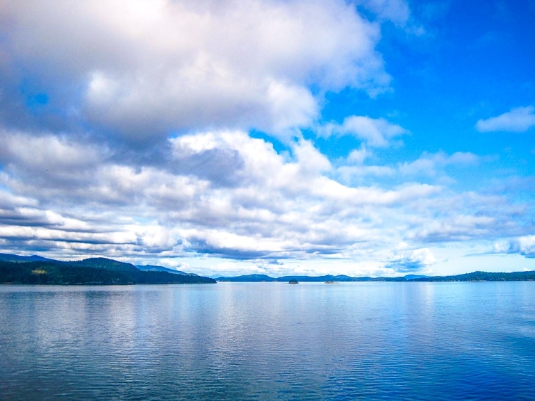 blue water with white clouds in sky during ferry crossing.