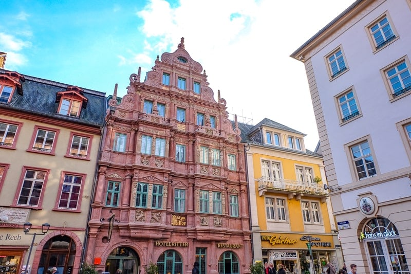 Altes rotes Hotelgebäude an öffentlichem Platz in Altstadt von Heidelberg