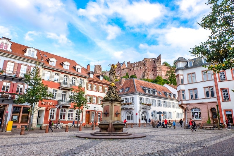 old town square with buildings and fountain in heidelberg germany