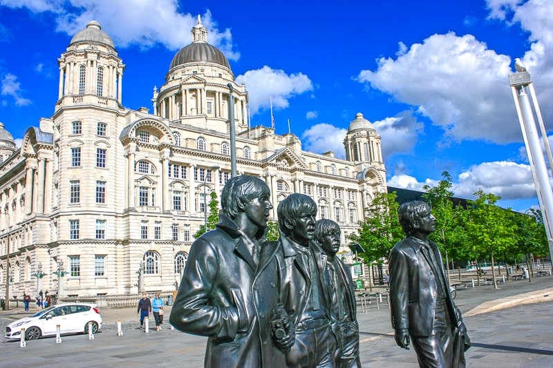 statues of the beatles in front of large building in liverpool