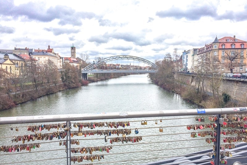 wire bridge with love locks over river in bamberg germany