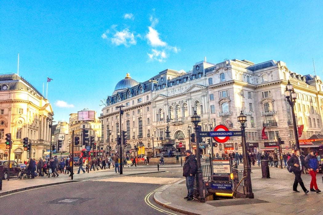 grosses kuppelgebäude mit Sonnenschein und Menschen, die die Strasse überqueren, in London England