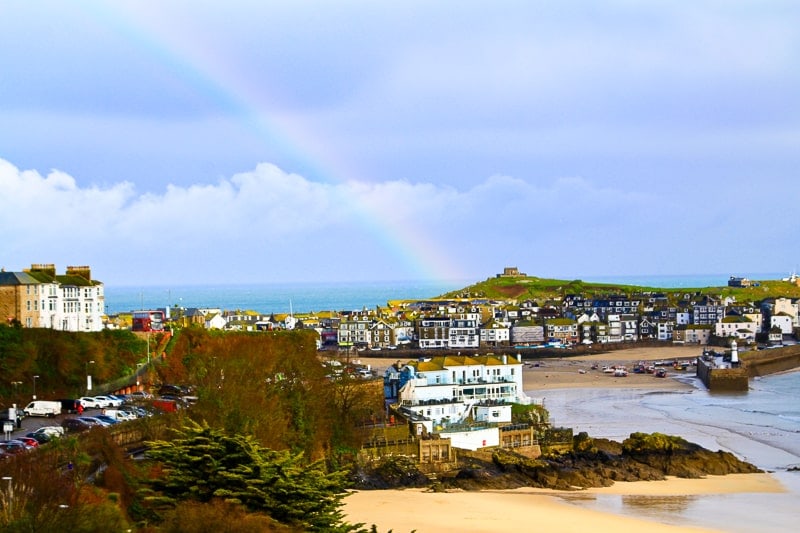 kleine Häuser am Meer mit Regenbogen in St Ives in Cornwall England