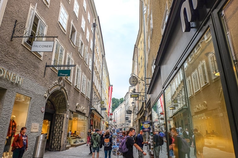 Einkaufsstraße mit laufenden Menschen und Geschäften