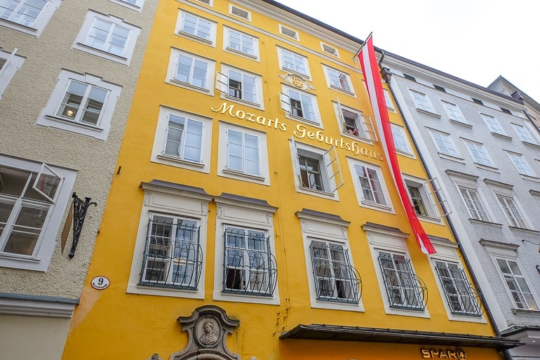 Gelbes Gebäude mit weiß roter österreichischen Flagge davor