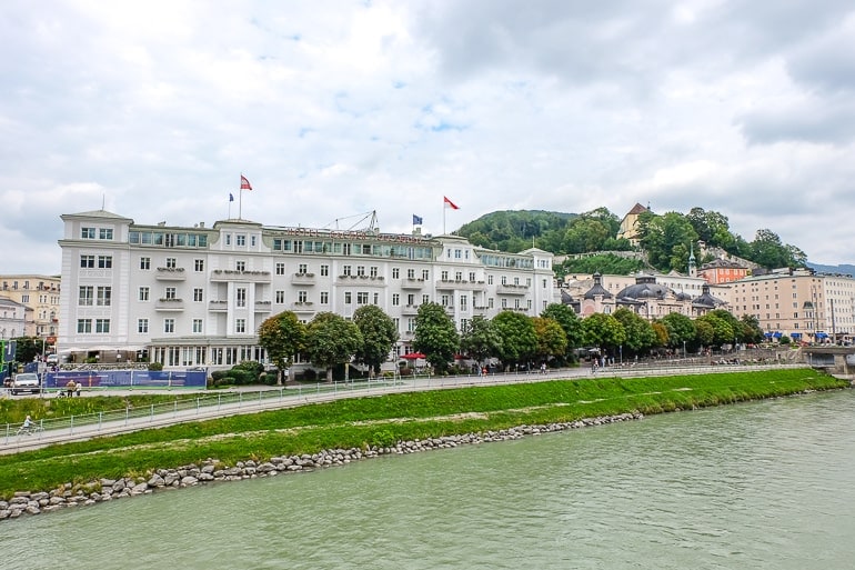 Altes weißes Hotel am Flussufer in Salzburg