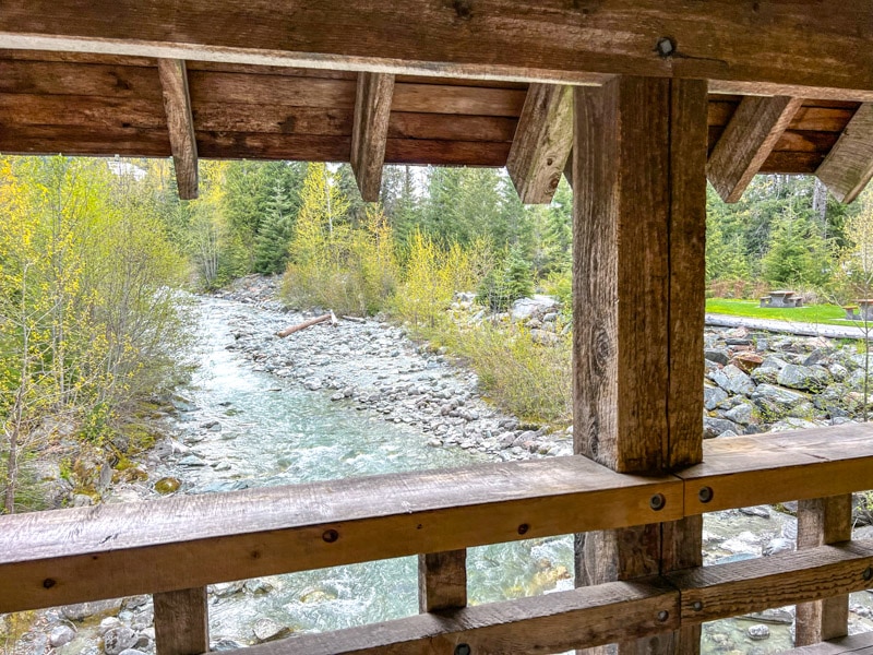 wooden covered bridge looking out over rocky stream below.