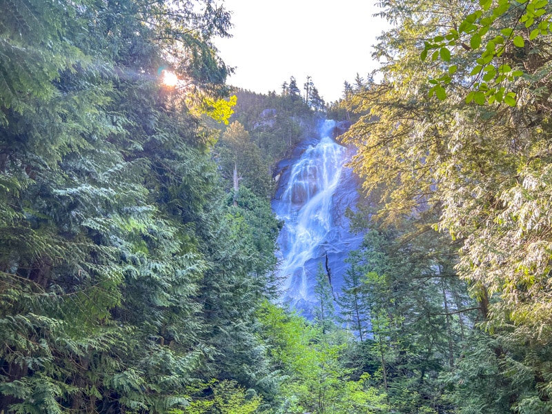 Wasserfall zwischen grünen Bäume auf beiden Seiten.