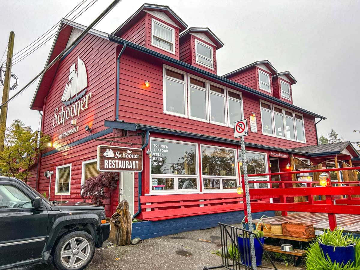 red restaurant building with truck parked beside and grey sky above.