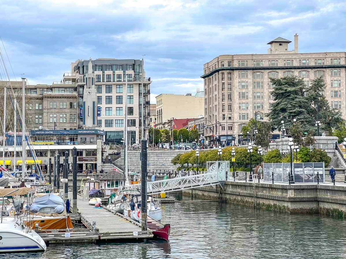 Aufnahme des Stadtzentrums von Victoria mit Gebäuden im Hintergrund und Booten im Hafen im Vordergrund.