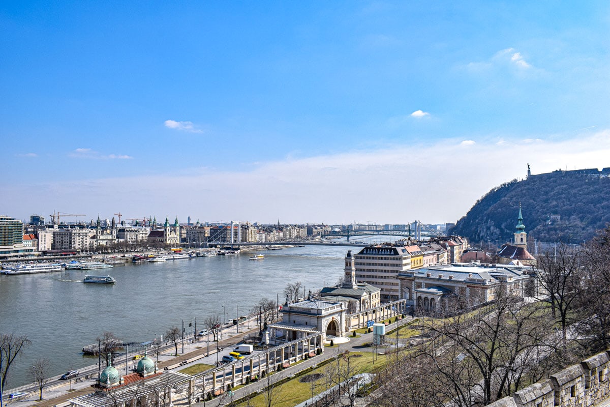 Blick auf die Donau von einem Hügel aus mit Gebäuden im Hintergrund.