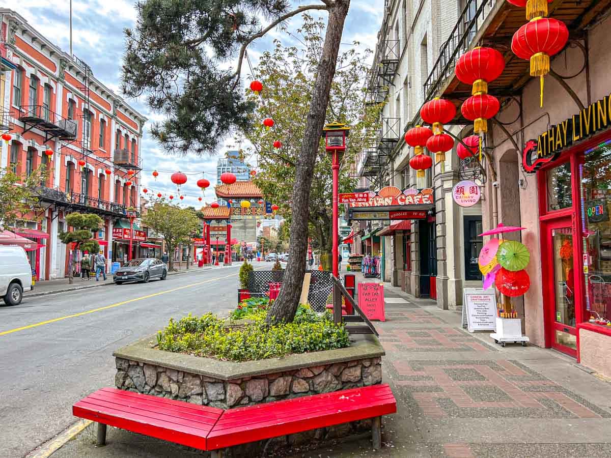 red bench and red storefronts on sidewalk in victorias chinatown area.