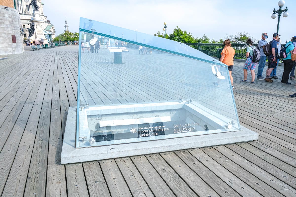 large glass structure with hole through boardwalk underneath.