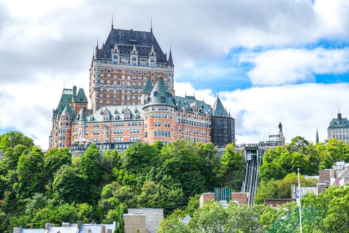fancy chateau frontenac hotel with towers and windows seen from far away in quebec.